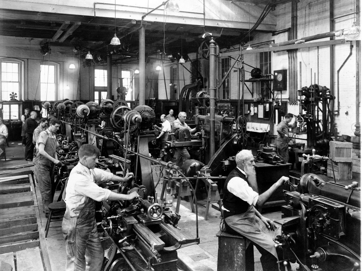 A government machine shop: rows of lathes, each with its own electric motor mounted on the machine.